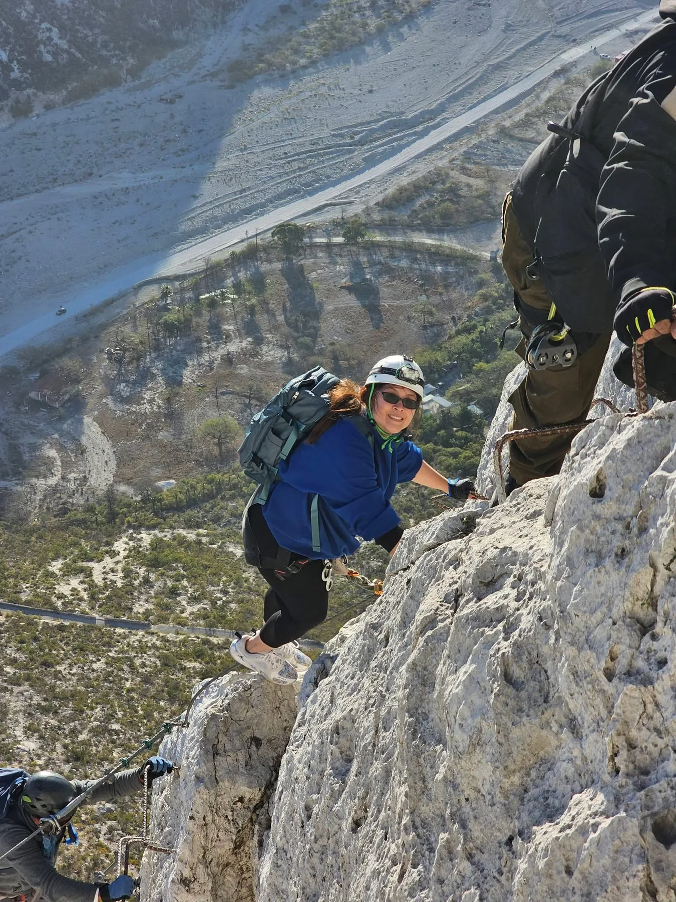 Aventurera escalando una pared de roca equipada